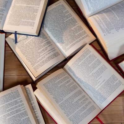 Close-up of various open book on a wooden table